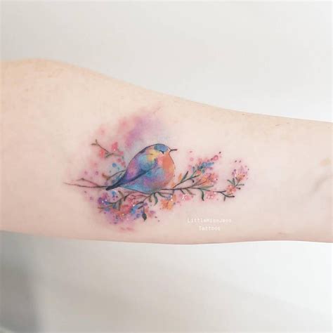 This tattoo uses watercolor to actually create the outline of the main design by adding the pigment to the area inverse to the actual image. . Watercolor bluebird tattoo